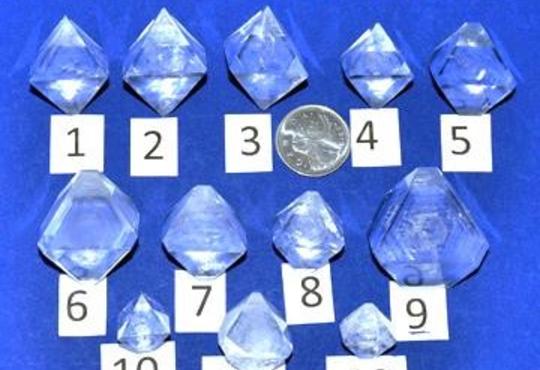 12 colourless crystals on a blue page 