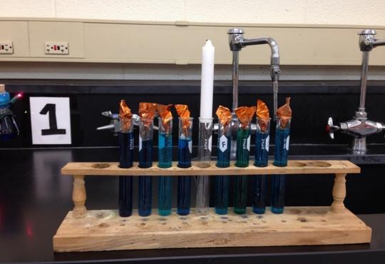 a test tubes with blue solution set up in a test tube rack to look like a menorah 