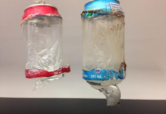 two pop cans with only the top and bottom metal -- the metal removed from the sides