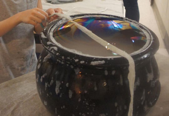 a dry ice coming of a cauldron with a large bubble on top