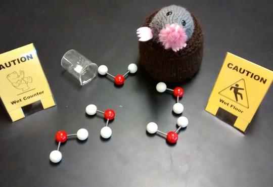 a knitted mole door stopper with plastic water molecules and 