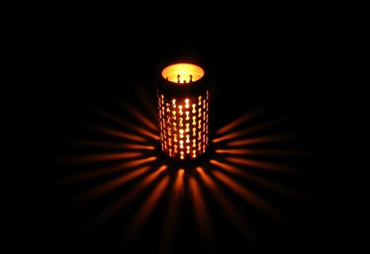 a soda-can lantern with holes glowing