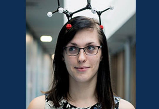 Lilli Temple-Murray with a plastic molecule on her head as a hat