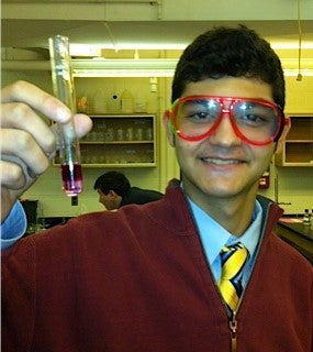 Boy holding test tube of phenolphthalein in NaOH.