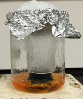 Aluminum foil filled with ice, small beaker and liquid inside large beaker.