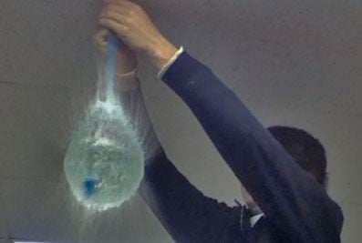 Person holding exploding water balloon.
