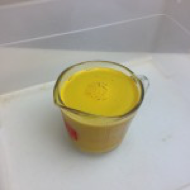 Orange liquid in a graduated mug.