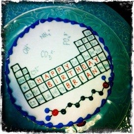 A round cake with a periodic table in icing.