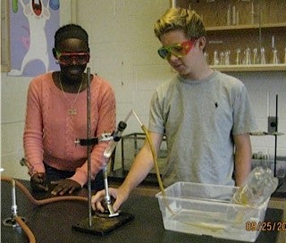 Two students assembling gas collection apparatus.