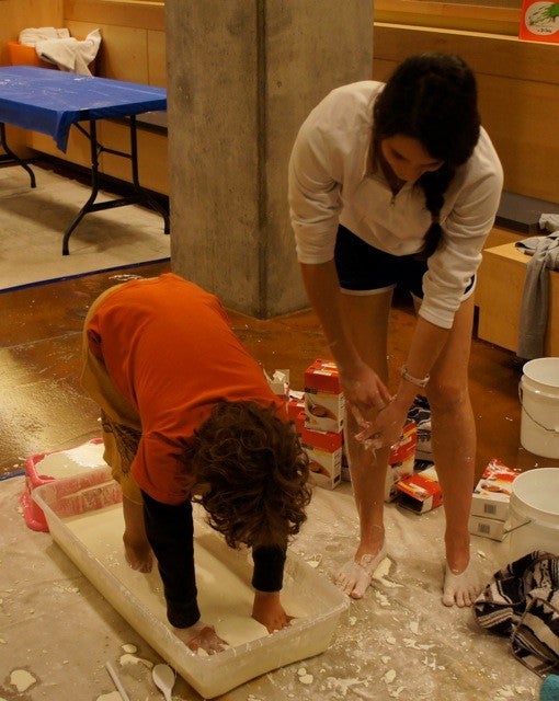 Two girls playing in mixture of cornstarch and water.