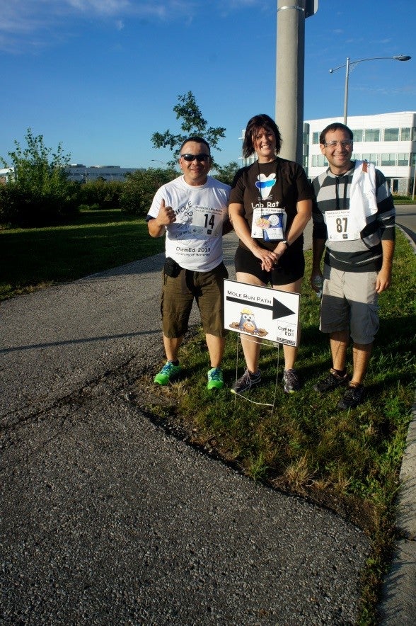Two men and one woman at a sign pointing to ‘Mole Fun Run’.