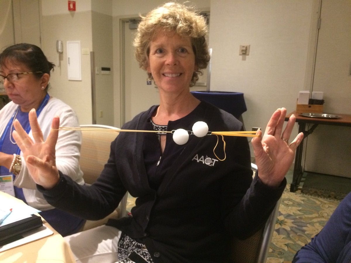 A simple electronegativity demonstration device Amiee Larchar Modic holding up two Styrofoam balls attached to elastics