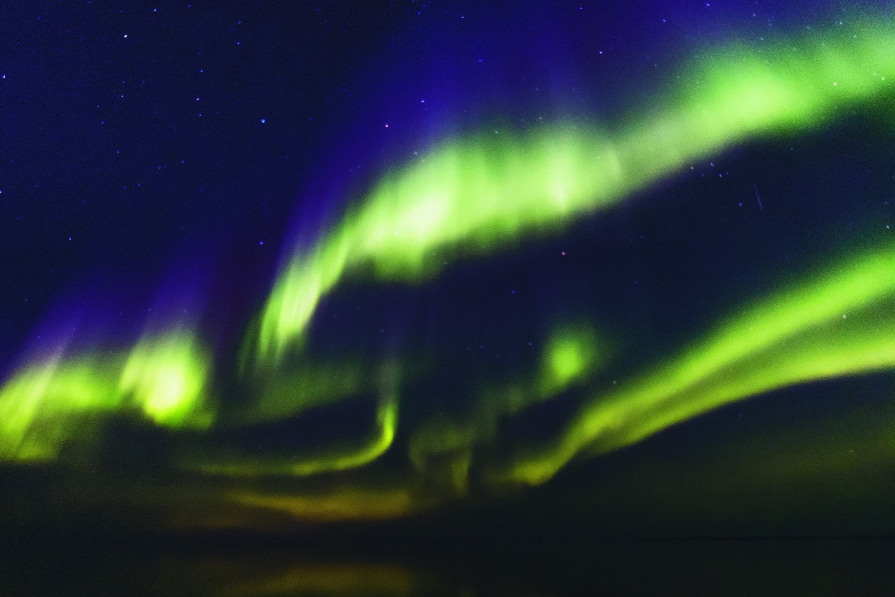 Aurora, showing the blue and green layers, at sea off Kitlineq (Victoria Island), an island shared between Inuvialuit and Nunavut.