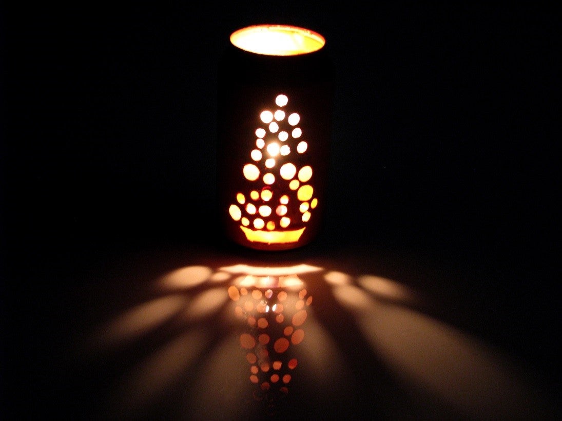 a soda-can lantern with holes glowing