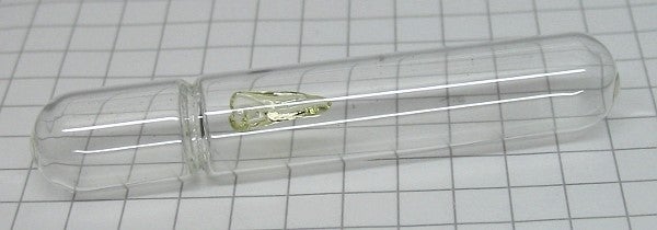 An ampoule with a yellowish shiny solid glob.