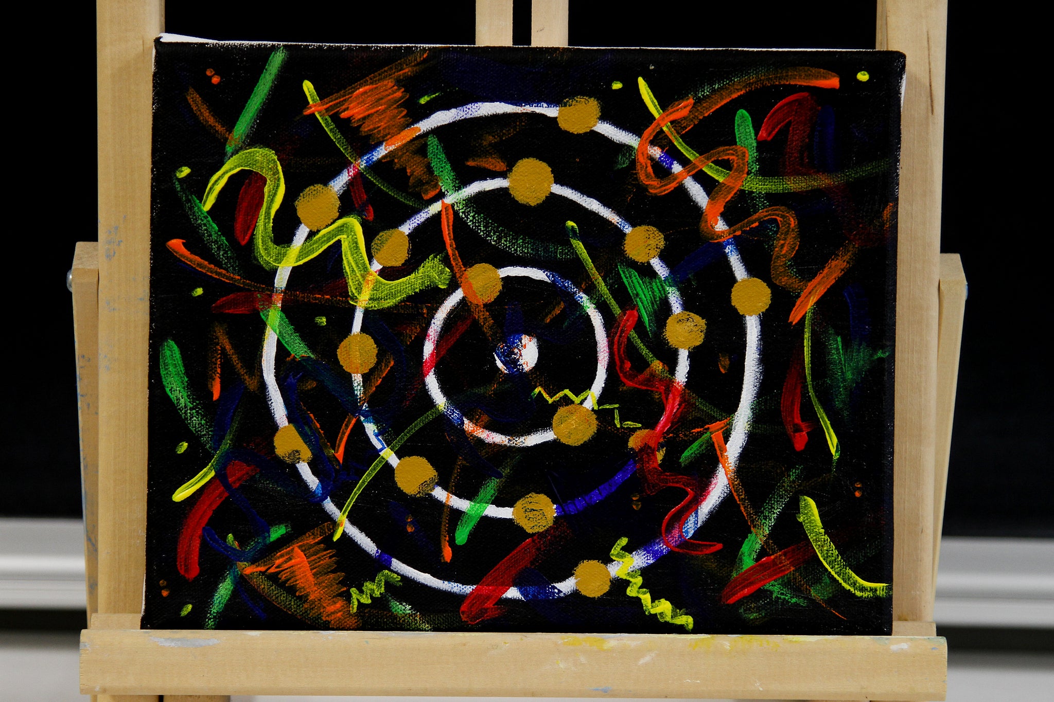 a painting with three white circles with yellow dots on each and colourful painted swirls