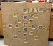 Spiral of stained glass tiles embedded in wood ready for installation 