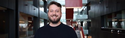 a man in a black sweater smiling 