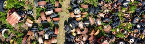 grass strewn with old tires and rusted metal