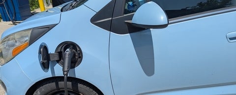a blue car with a charging cable attached