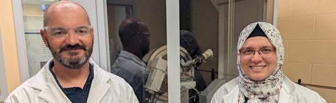 a man and a woman in lab coats smiling