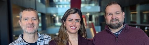 two men with a woman between them smiling