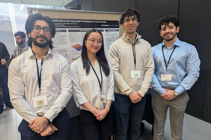 a woman and four men standing in front of a poster board