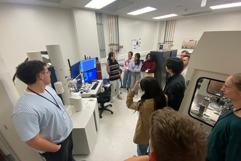People looking at equipment in front of a monitor