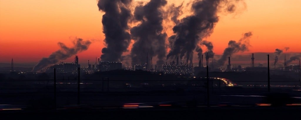 Air pollution streaming out of smoke stacks at dawn