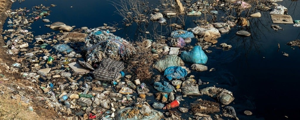 water and a shore covered in plastic waste