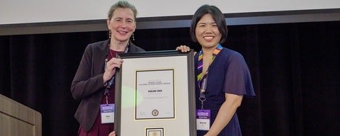 Dean Mary Wells and Baoling Chen holding an award