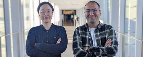 a woman and man smiling with their arms crossed