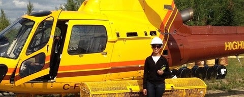 Sarah Vandaiyar standing in front of a yellow helicopter