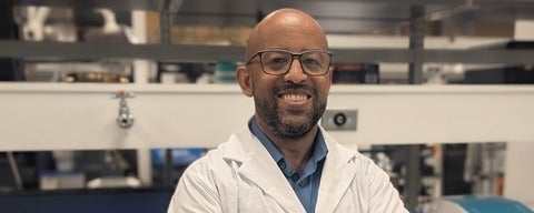 a bald man with a beard and glasses smiling