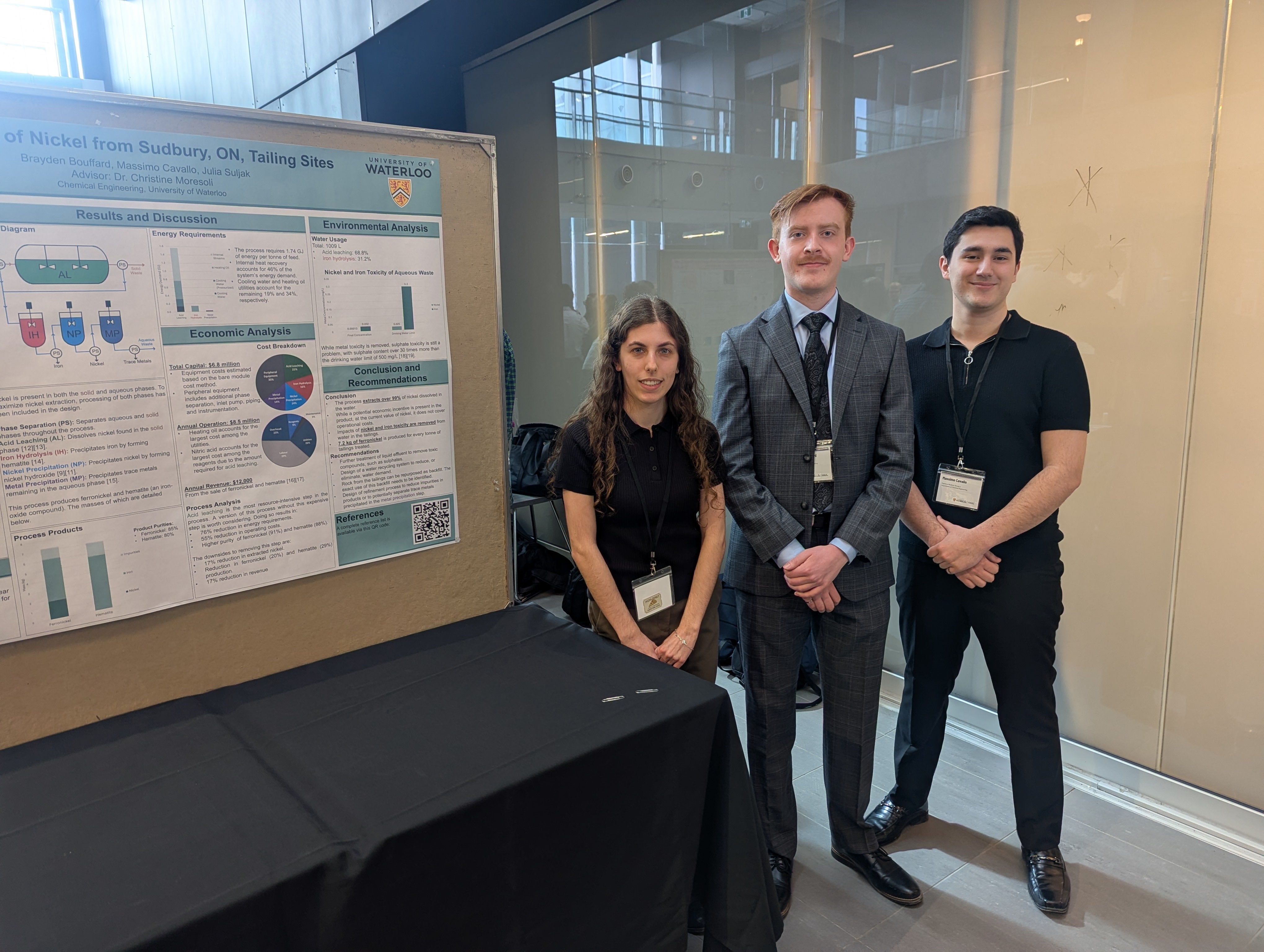 a woman and two men standing in front of a poster board