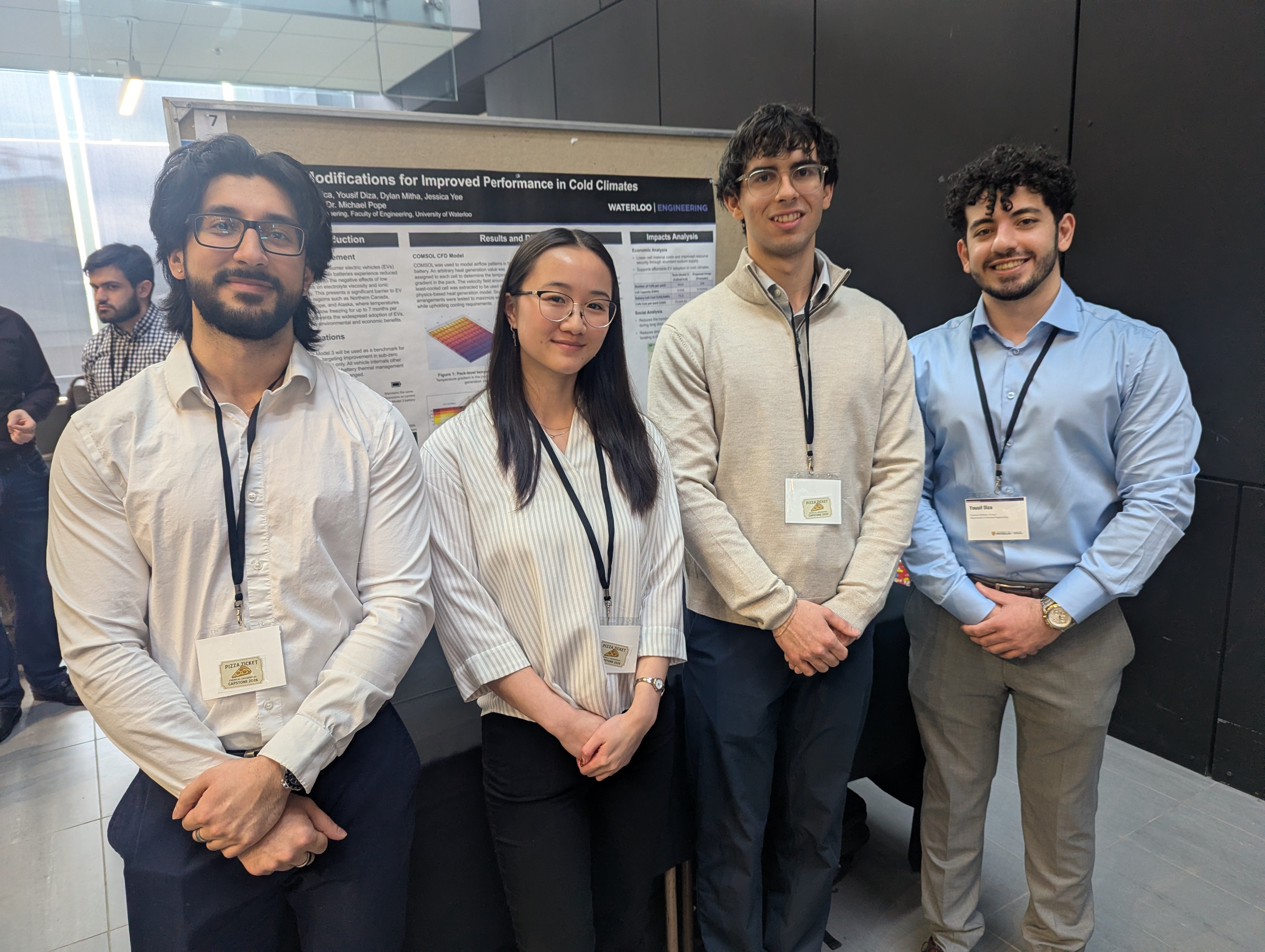 a woman and four men standing in front of a poster board