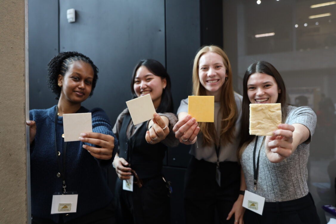 four women holding squares