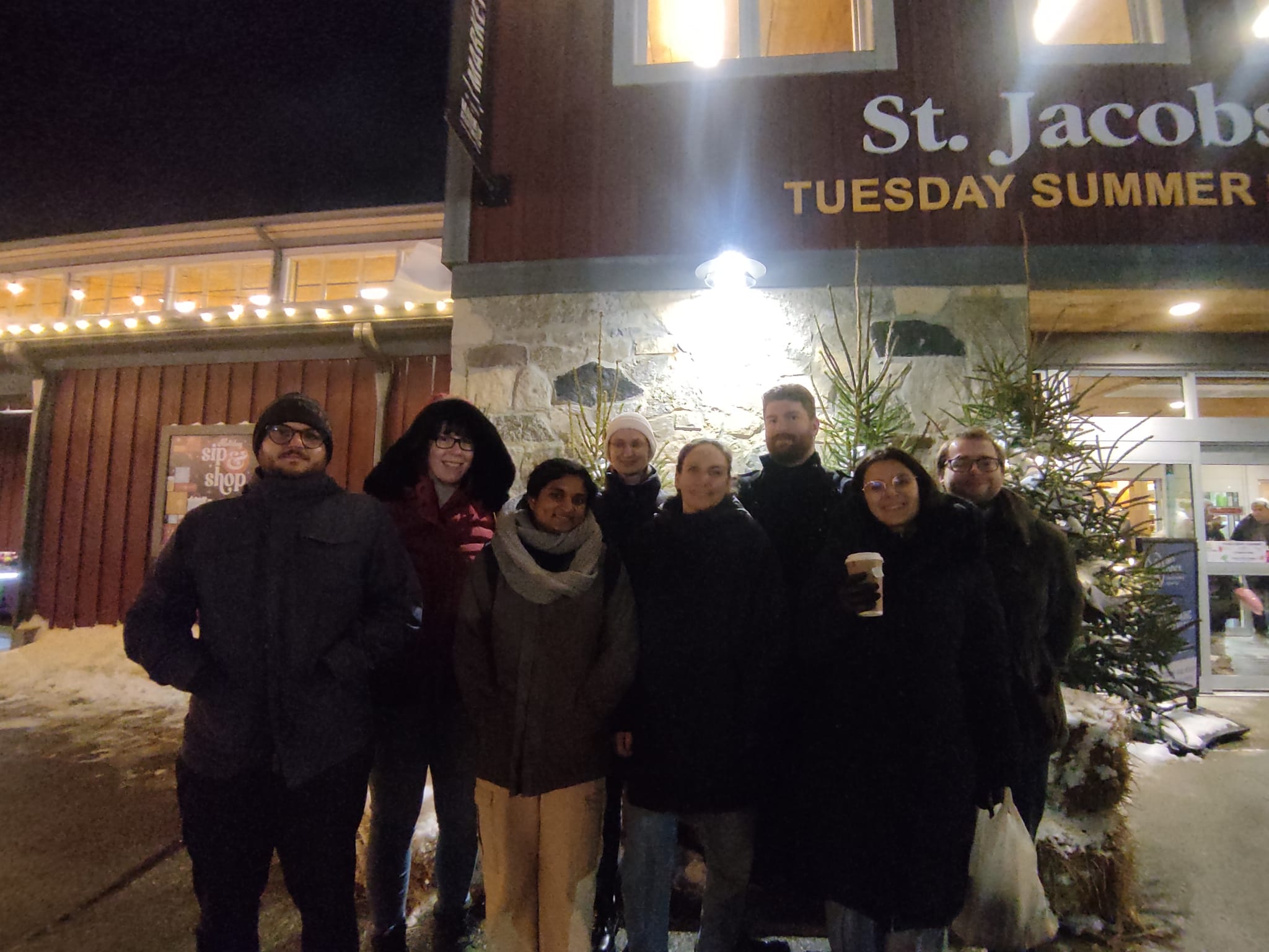people in winter coats in front of a St. Jacob's sign