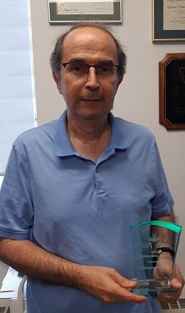 Professor Costas Tzoganakis holding an award