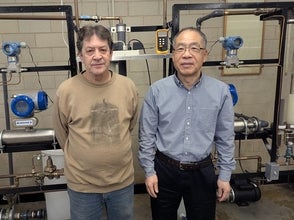 two men standing in front of equipment