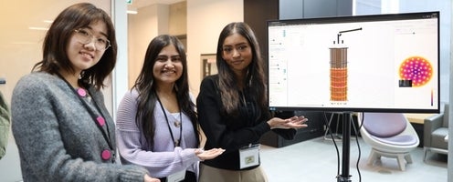 three women gesturing to a tv monitor
