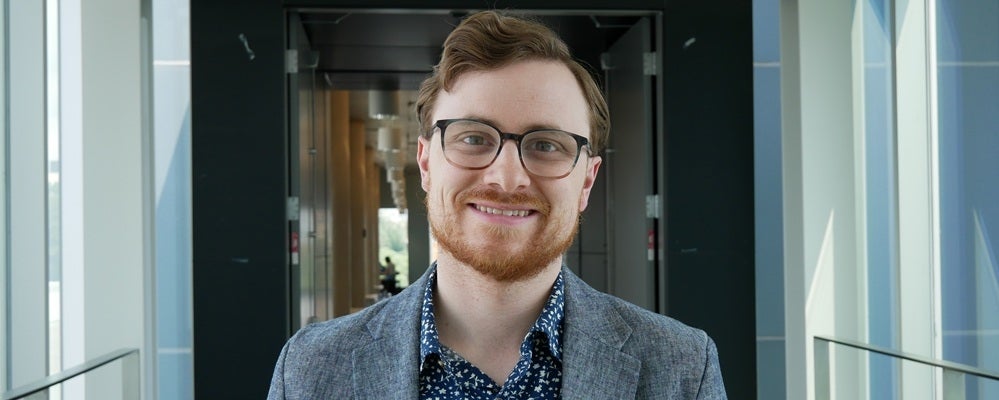 man with red hair and glasses smiling