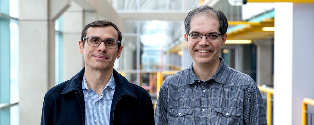 Two men with glasses smiling