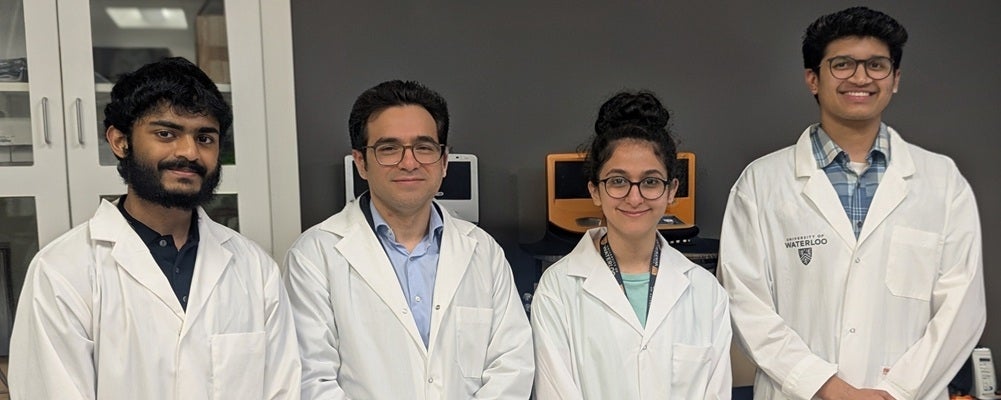 three men and a woman in lab coats