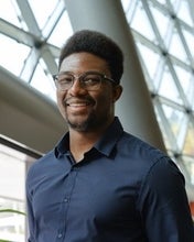 a man with glasses wearing a blue shirt