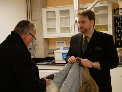 Michael Kerzner with Drew Davidson looking at his mother's jacket