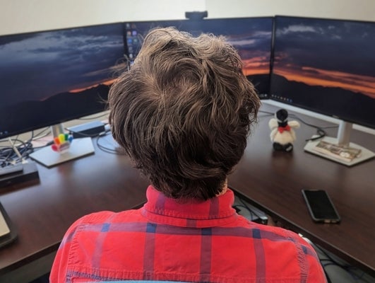 a man sitting in front of computer screens