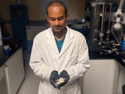 a man in a lab coat holding seeds