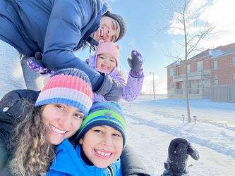 a mother and father with their two children dressed for winter with hats and jackets