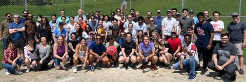 Graduate students posing on baseball diamond.